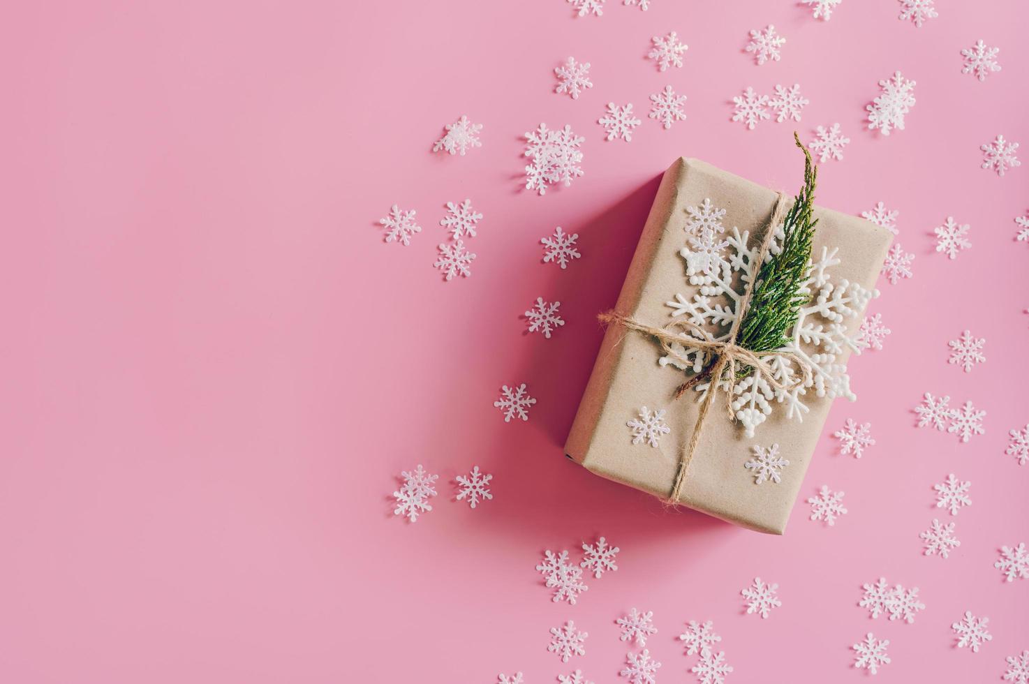 Brown gift box on the pink background with christmas decoration. Minimal styled holiday card with copy space. photo