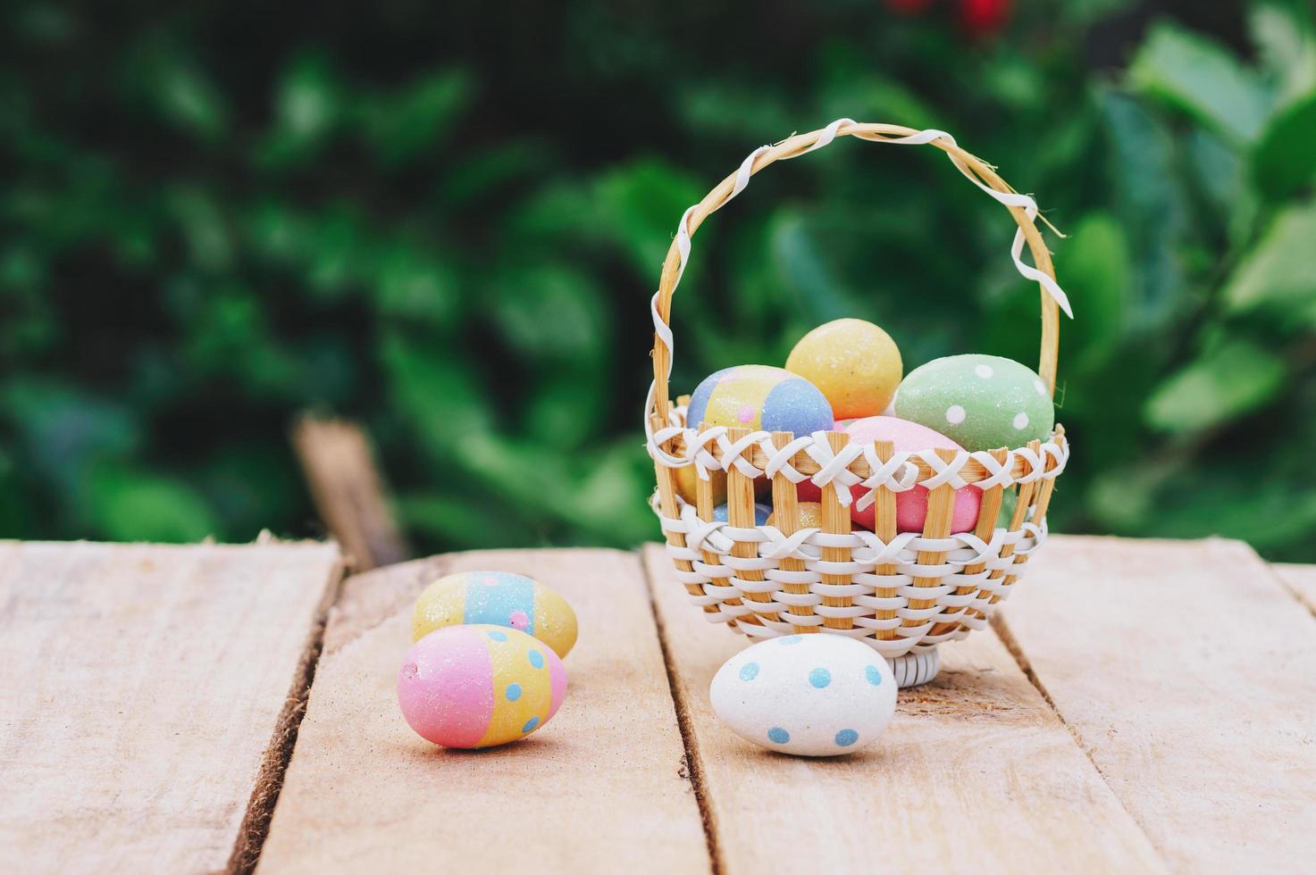 Colorful easter eggs in basket on wooden table win copy space. photo