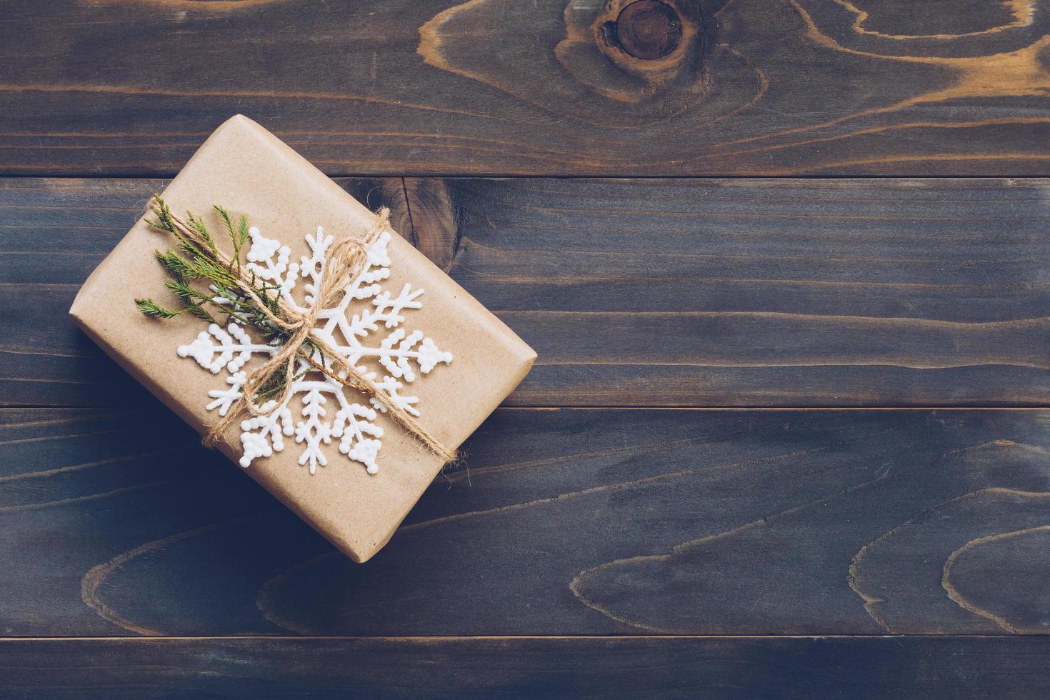 String or twine tied in a bow on kraft paper. Above gift box on wood with space. photo