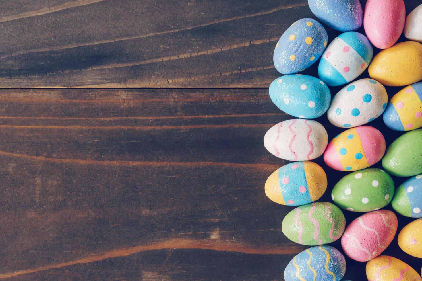 Top view of Easter eggs on rustic wood background with copy space photo