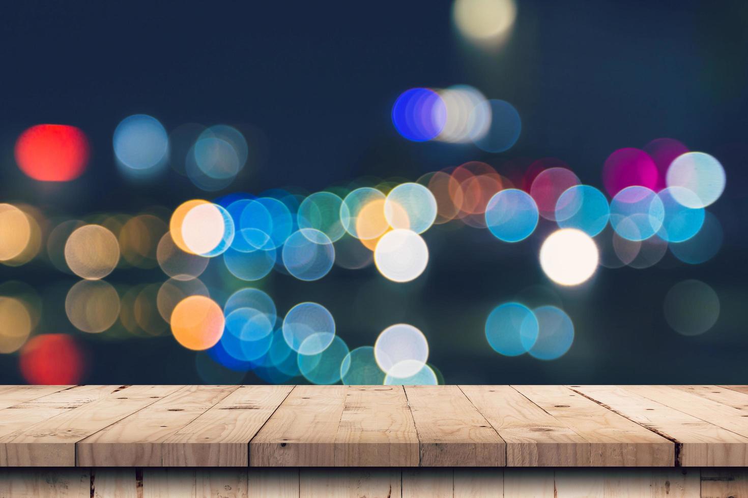 Abstract defocused bokeh night background and Empty wooden table with display montage for product. photo