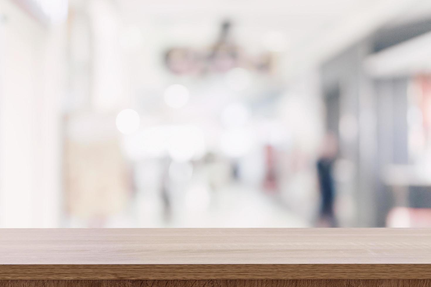 Empty wooden table top with blurred modern shopping mall background for product display and montage. photo