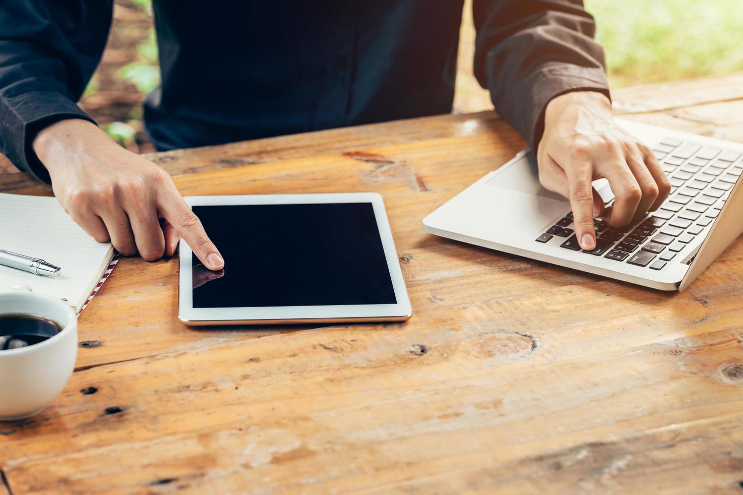 Business man using tablet on wood table in coffee shop. photo