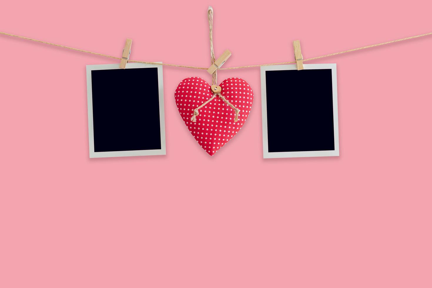 Blank instant photos and red heart hanging pastel color background.