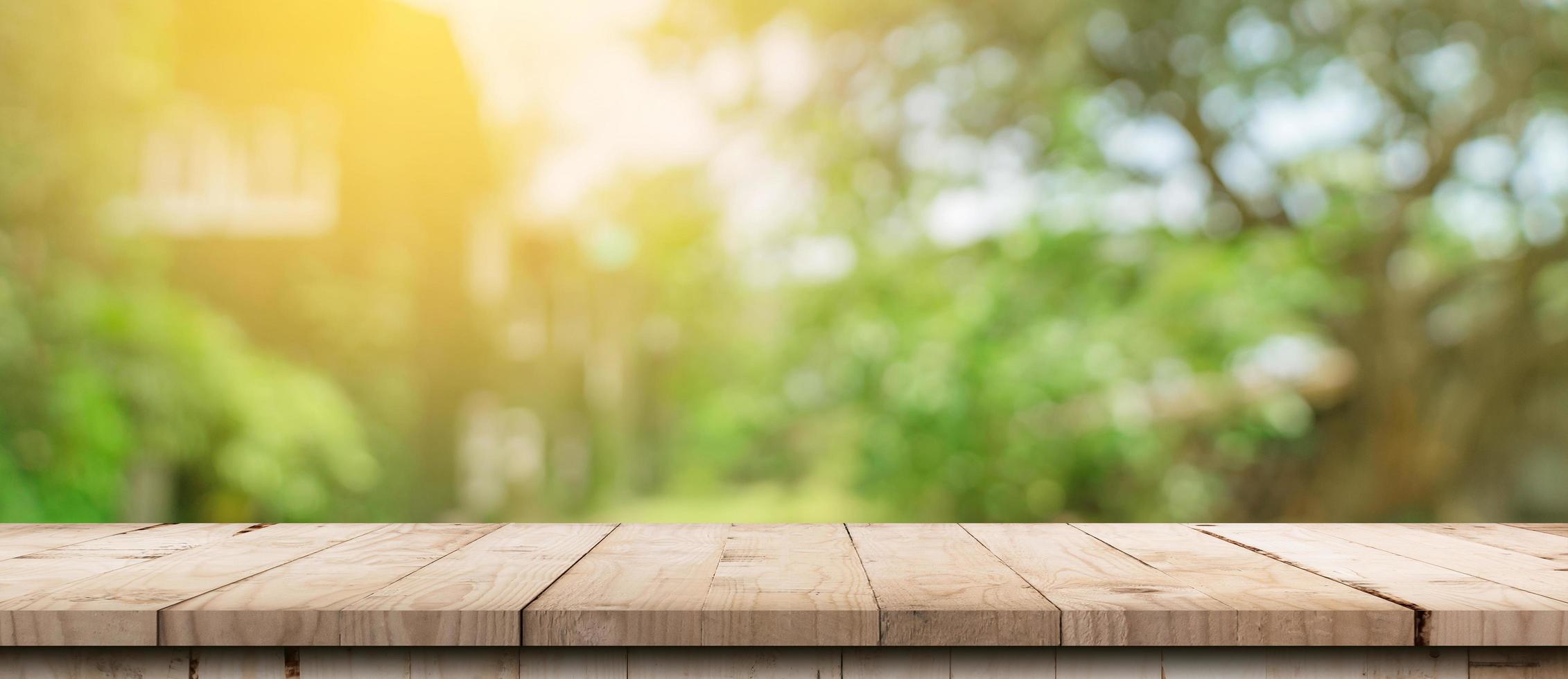Empty wood table and defocused bokeh and blur background of garden trees with sunlight. product display template. photo