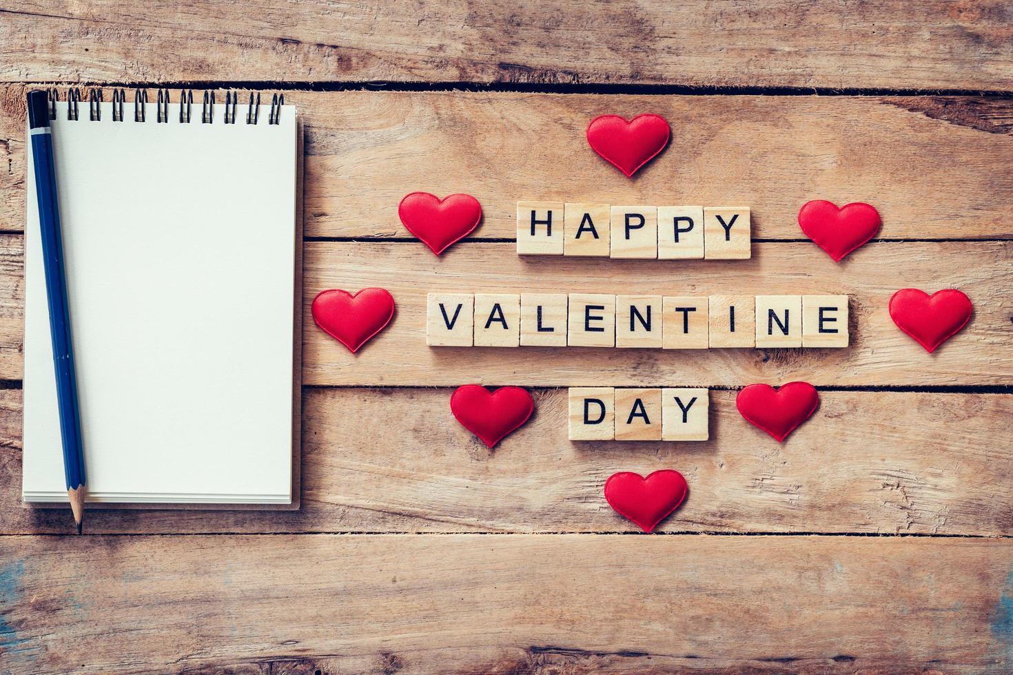 Blank notebook and wood text for Happy Valentine Day with red heart on wood background. photo