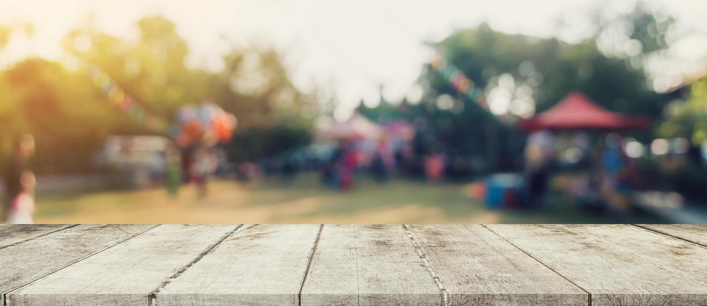 Empty wood table and defocused bokeh and blur background of garden trees in sunlight, display montage for product. photo