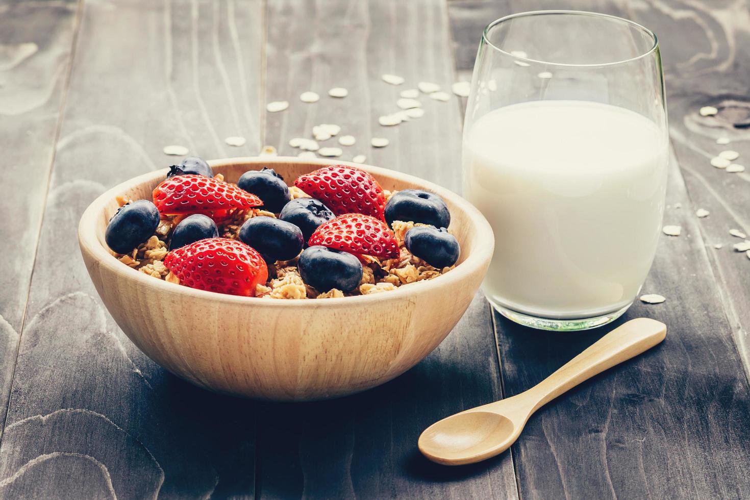 Homemade granola with strawberry and fresh berries on wood table. photo