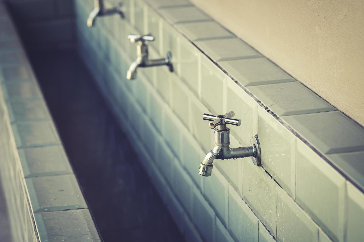 row of steel taps into a large bathroom photo