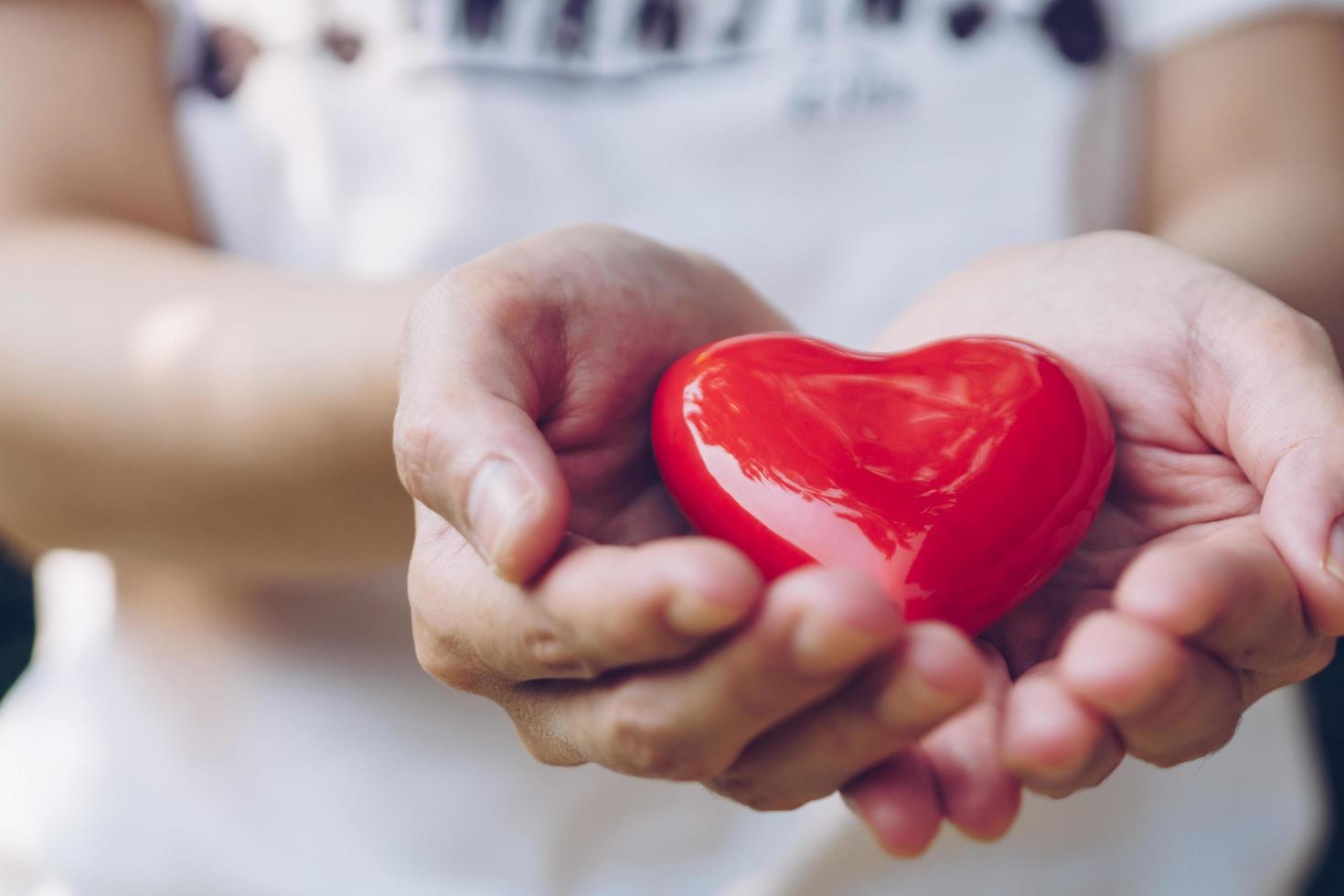 Close up female hands giving red heart on hands photo