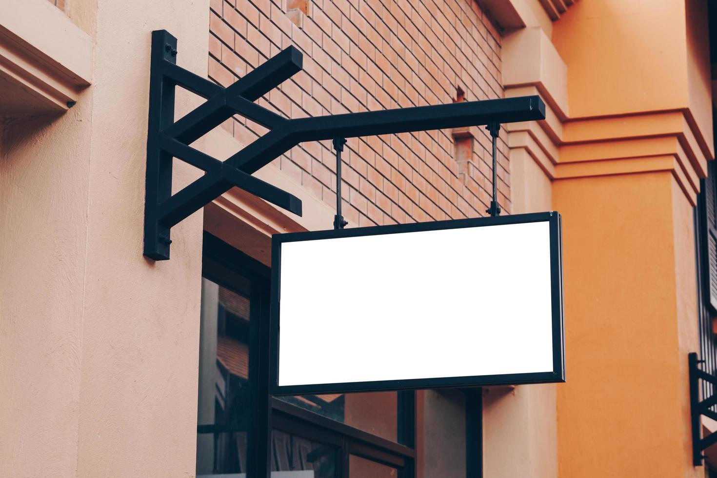 Empty signage and blank mock up hanging on street with copy space photo