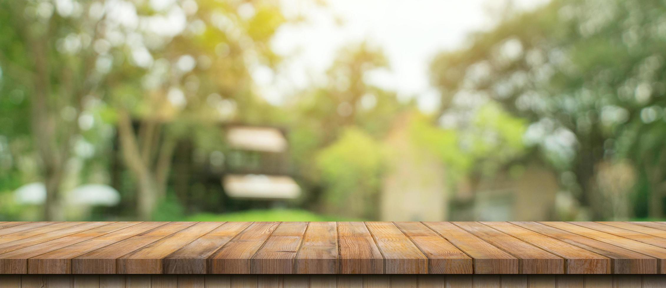 Empty wood table and defocused bokeh and blur background of garden trees with sunlight. product display template. photo