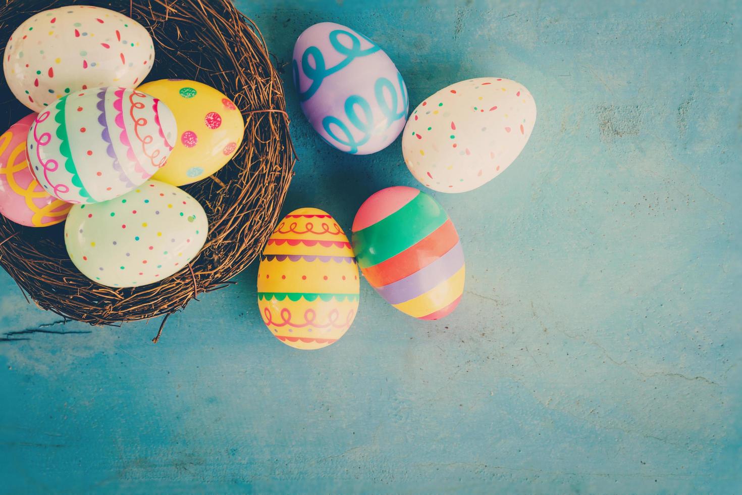 vistoso Pascua de Resurrección huevo en el nido en azul pastel color madera antecedentes con espacio. foto