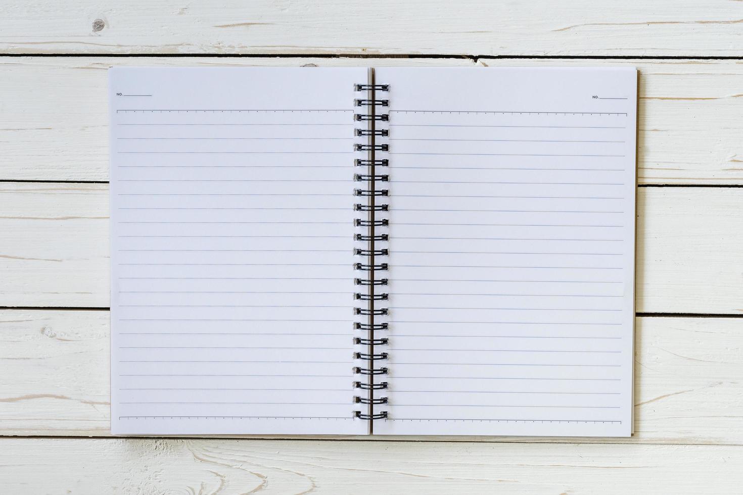 Open notebook with blank pages on wood table photo