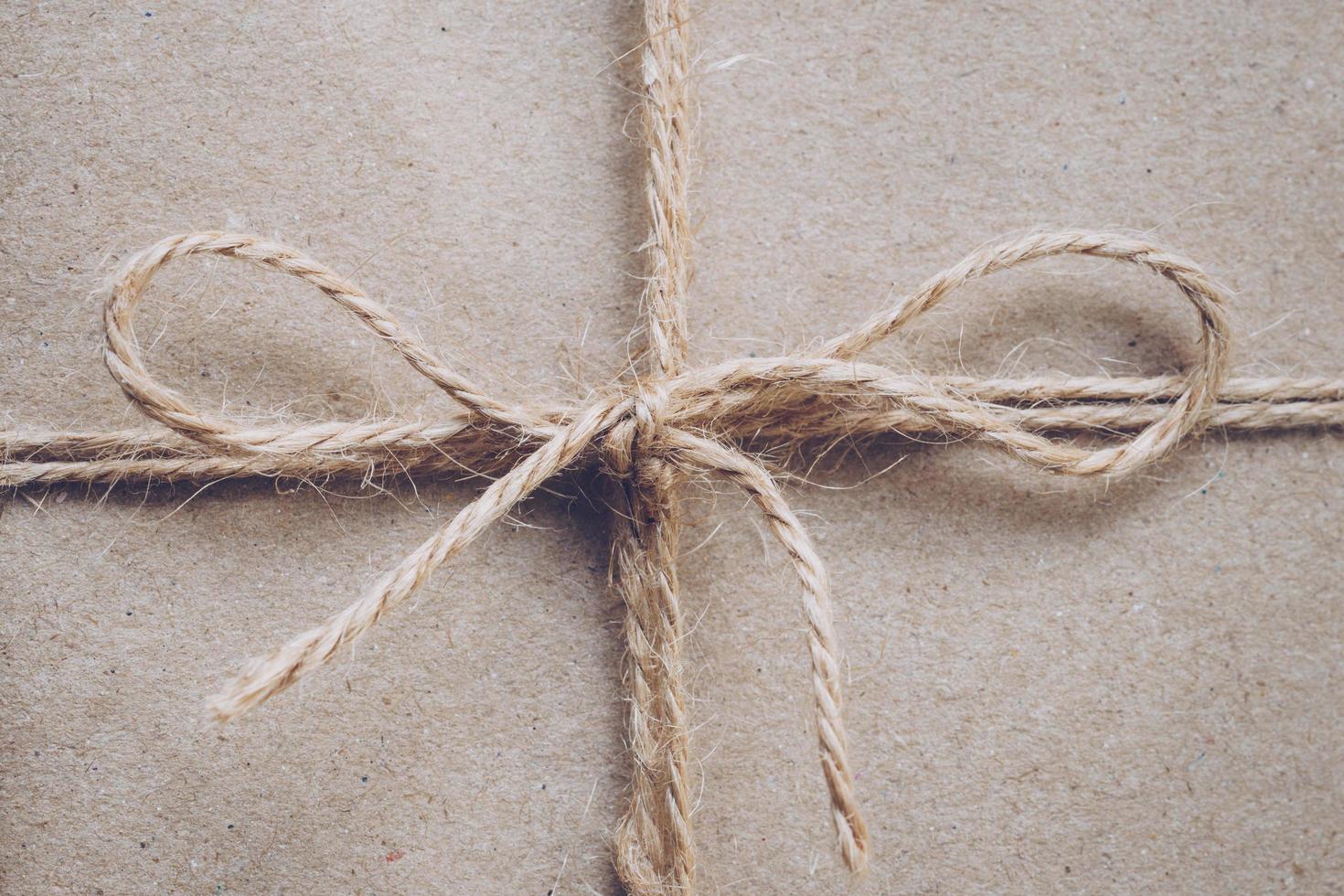 String or twine tied in a bow on kraft paper texture photo