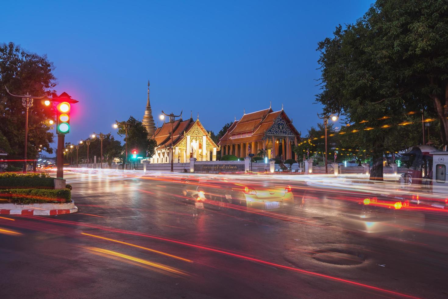 Buddhist temple of Wat Pra Tard Chang Kum in Nan, Thailand with trafic jam at night scene. photo