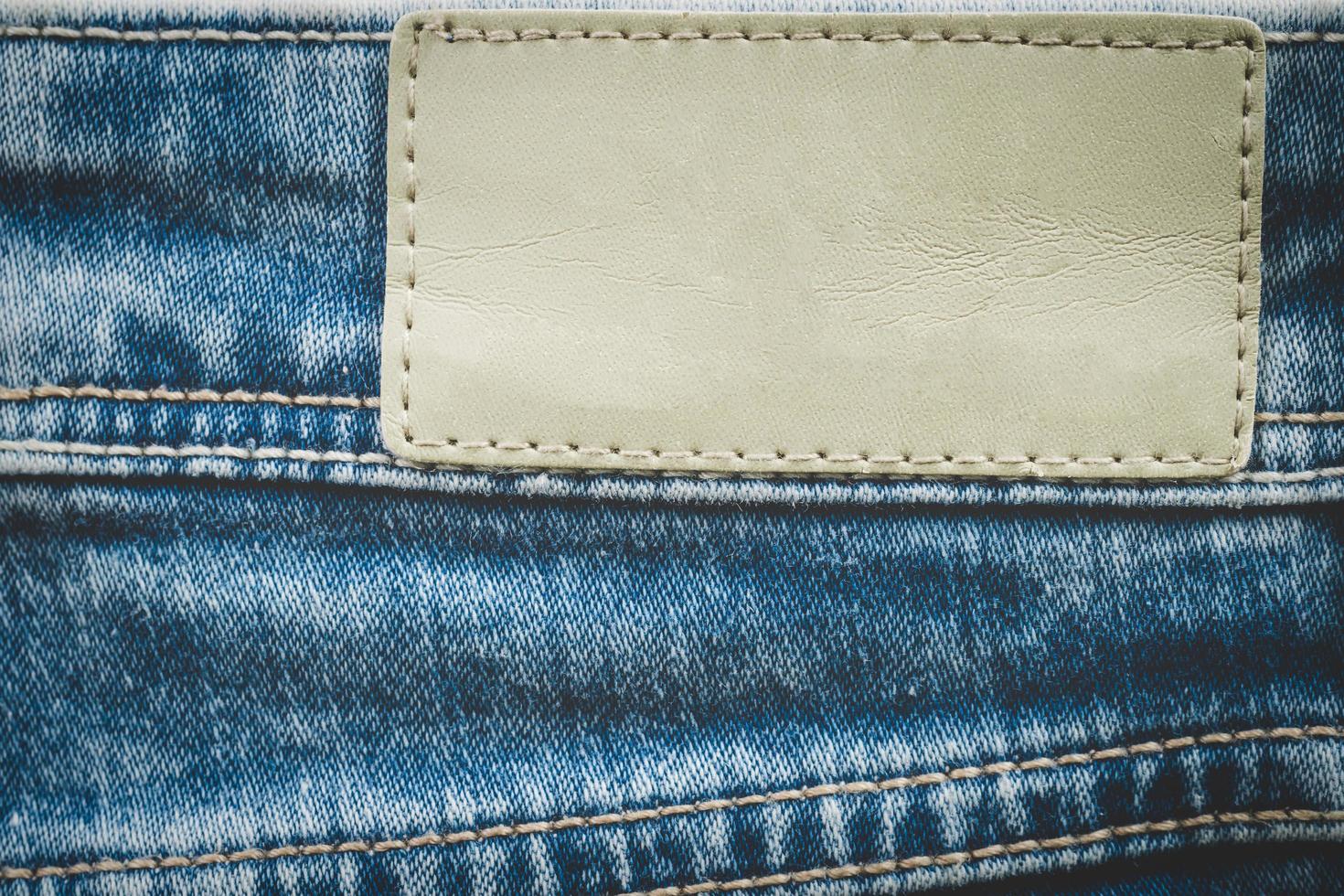 Empty leather label on jeans background with copy space photo