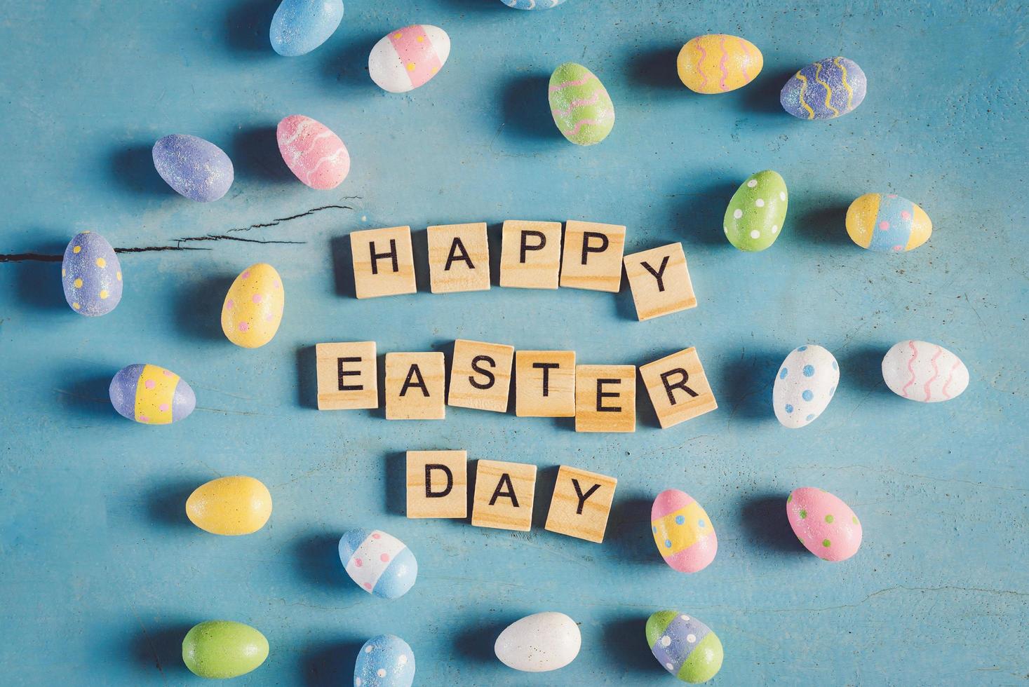 Colorful easter egg and wood text Happy Easter Day on blue pastel color wood background with space. photo