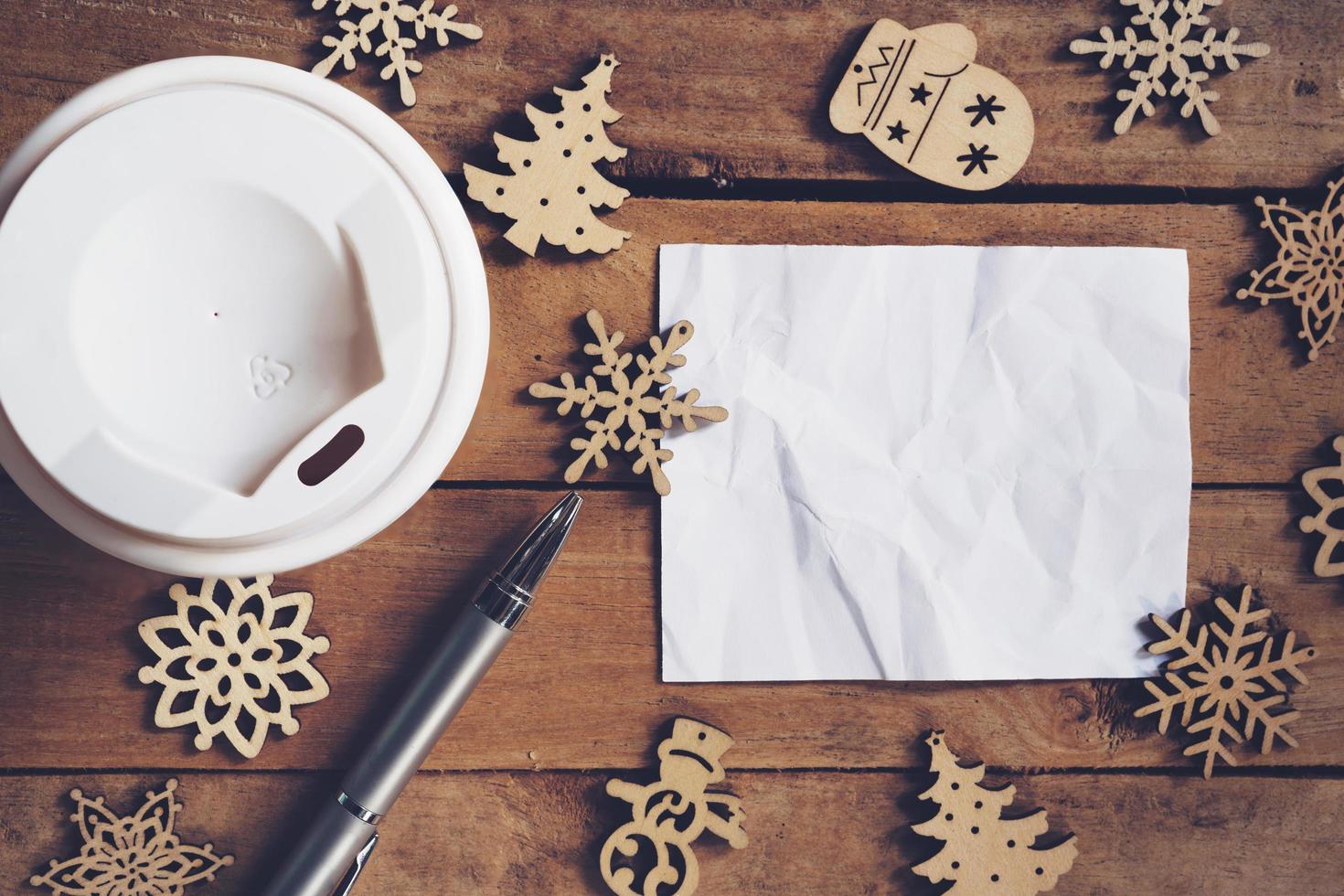 Top view cup coffee and pen, empty paper on wood with christmas decoration for New year concept. photo