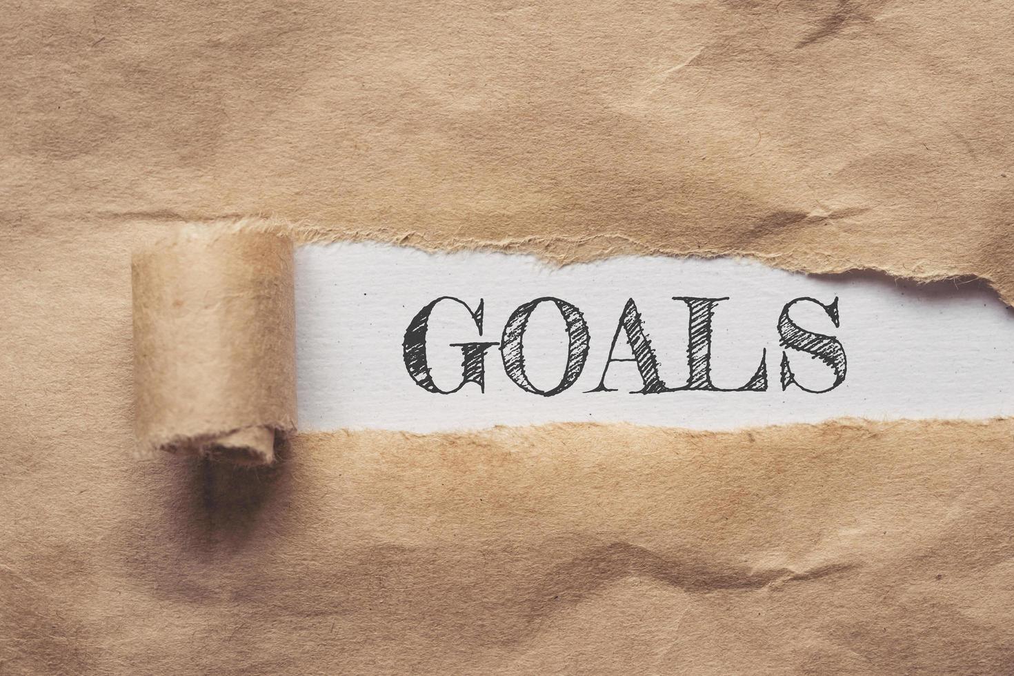 Business and finance. Torn brown paper on a white background, the text - Goals photo