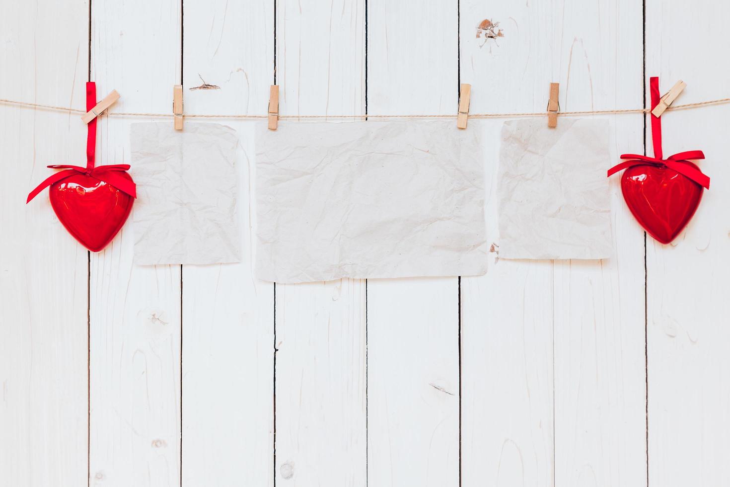 rojo corazón y antiguo papel blanco colgando a tendedero en madera blanco antecedentes con espacio. enamorado día. foto