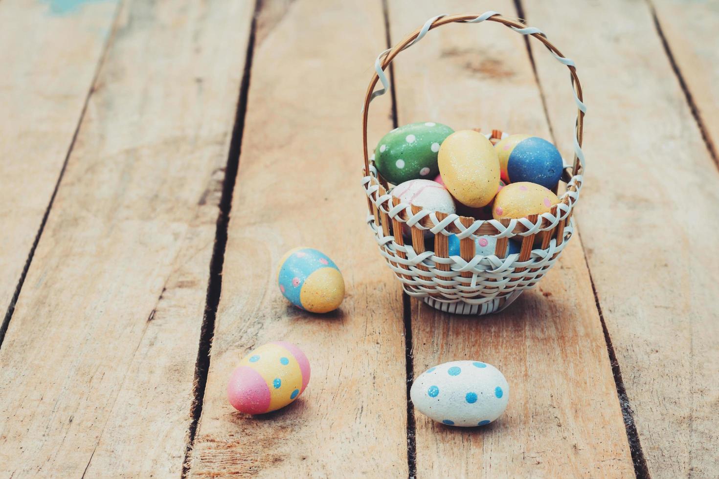 colourful easter egg and basket on wood background photo