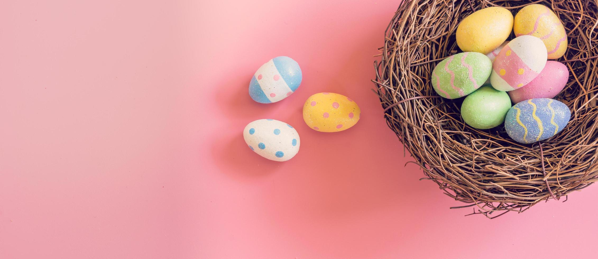 Colourful easter egg and nest on pastel colour background with copy space photo