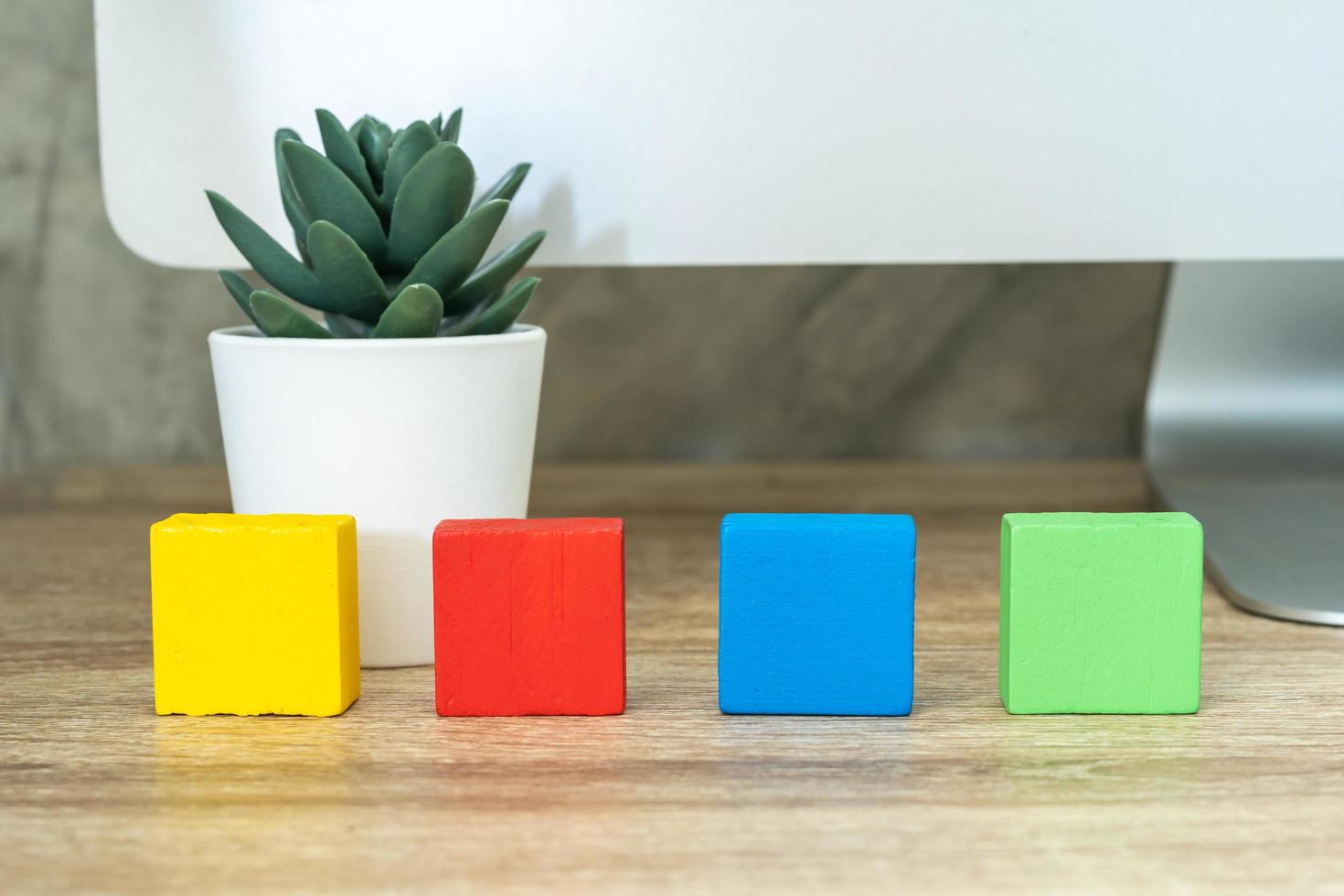 Four wooden toy cubes blocks on wooden table background with copy space photo