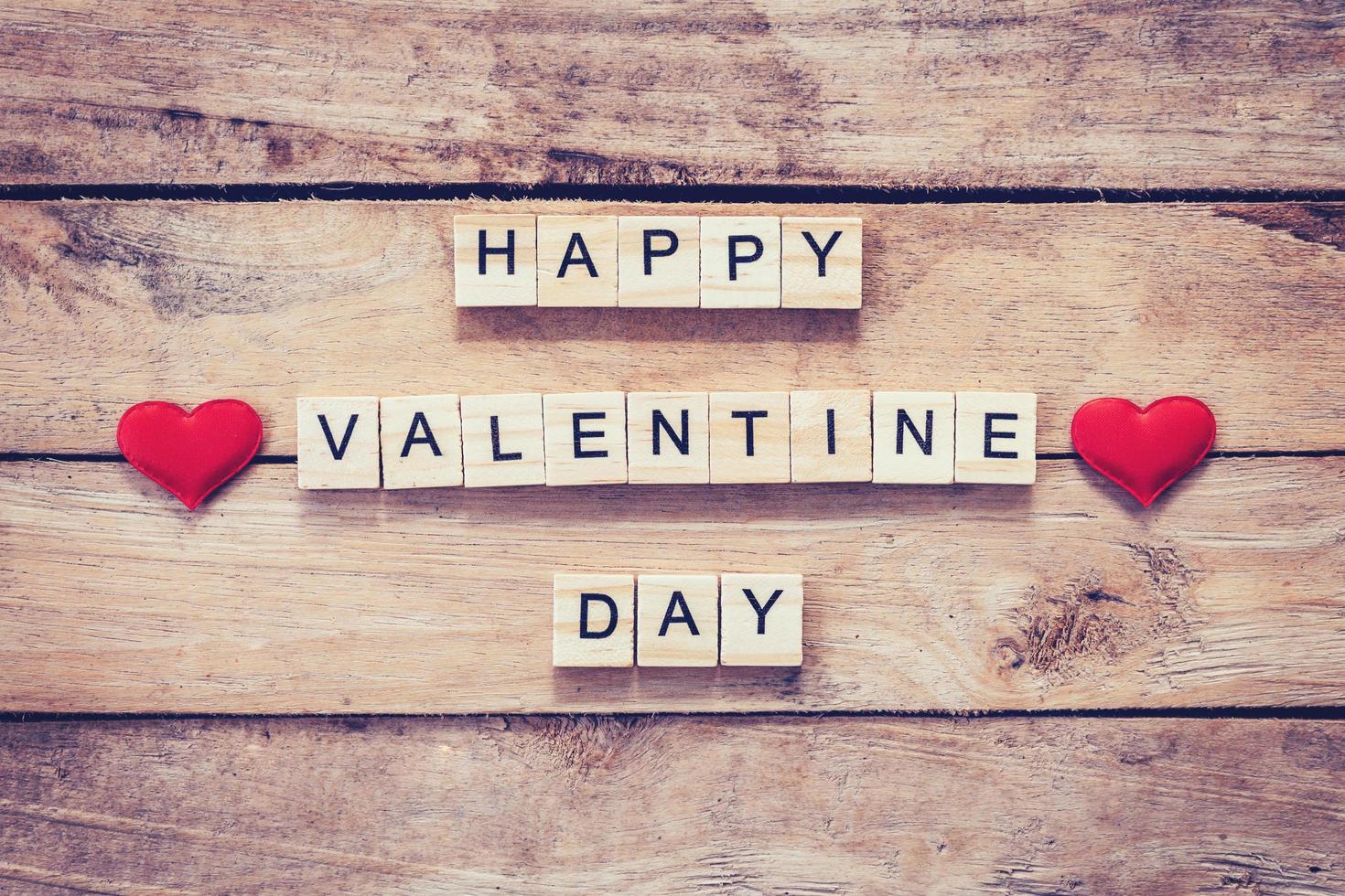 Red heart and wooden text for Happy Valentine Day on wood table background. photo