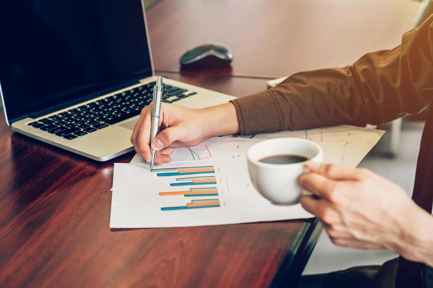 business man writing paper sheet on wood table in office. photo