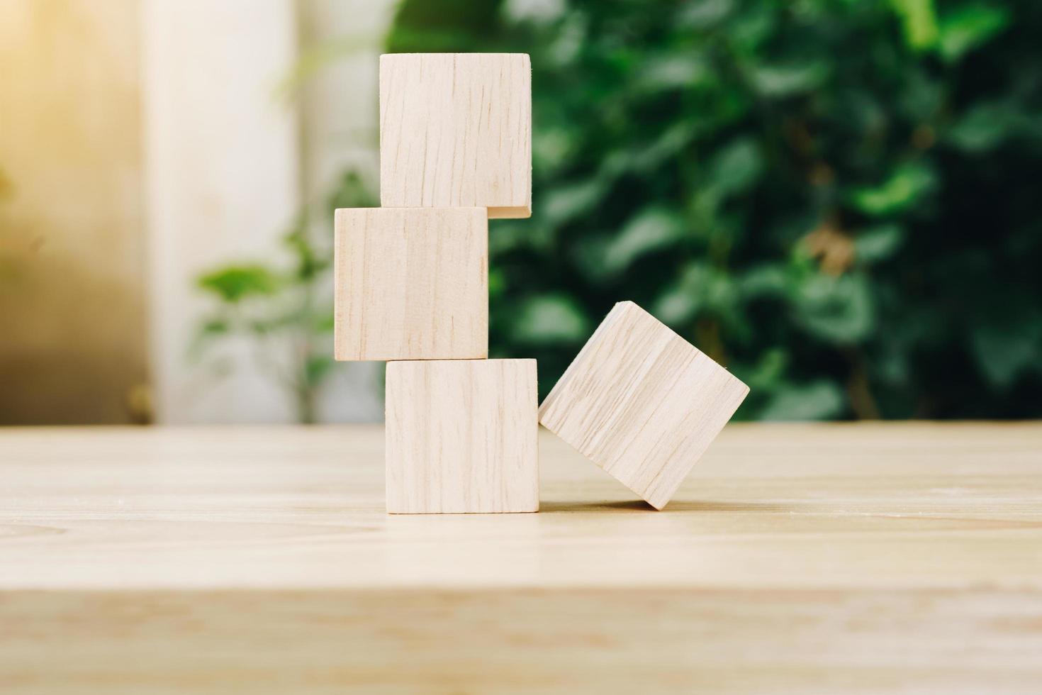 Four wooden toy cubes on wooden table background with copy space photo