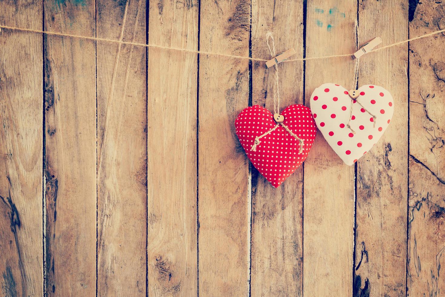Two heart fabric hanging on clothesline and wood background with space. photo