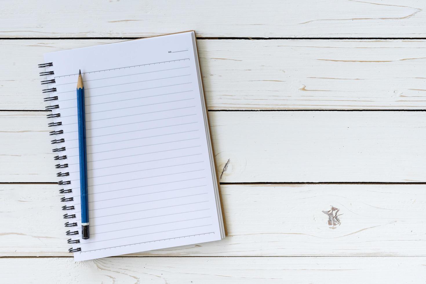 abierto cuaderno con blanco paginas y lápiz en madera mesa foto