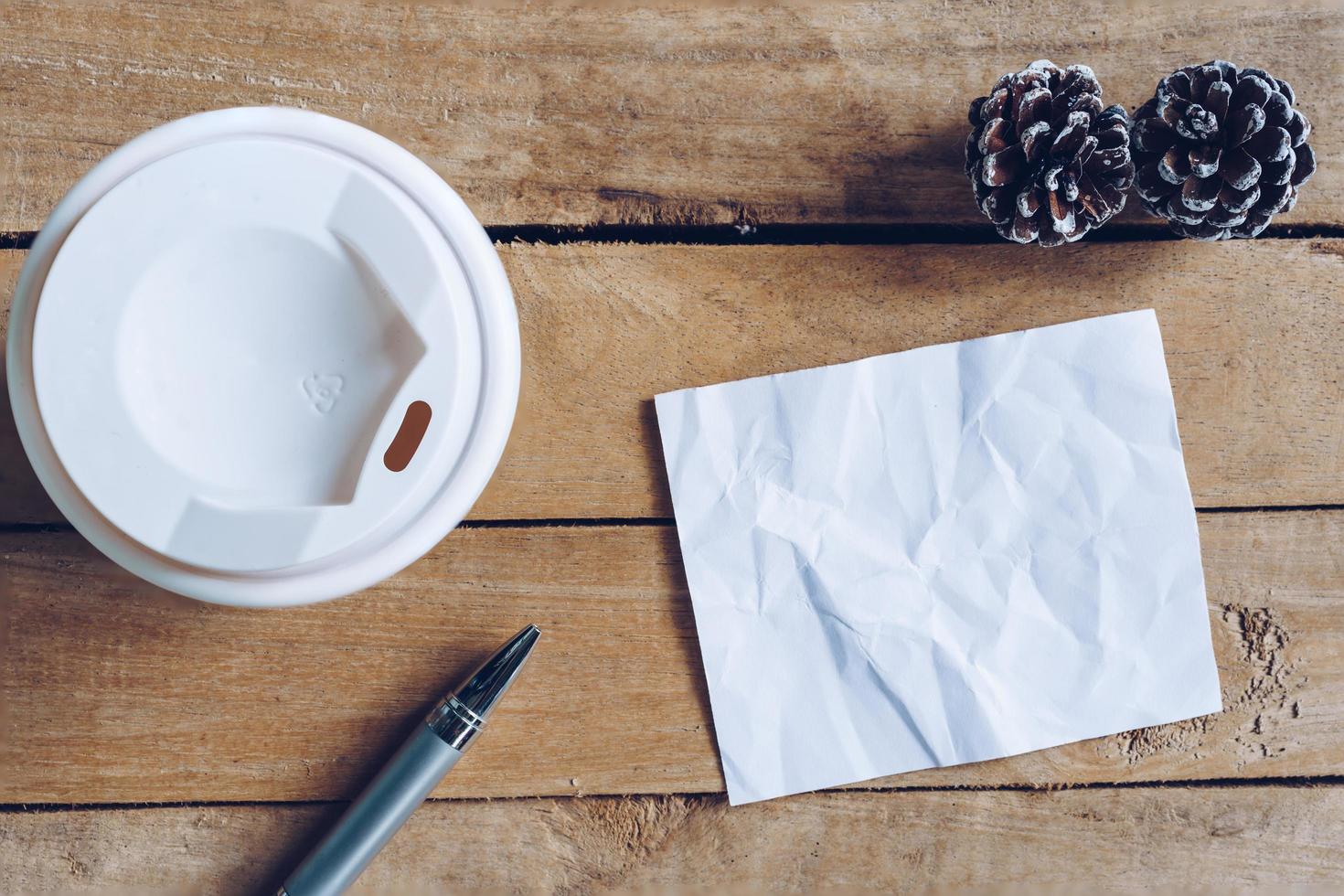 parte superior ver café taza y bolígrafo, blanco papel en madera con Navidad decoración para nuevo año concepto. foto