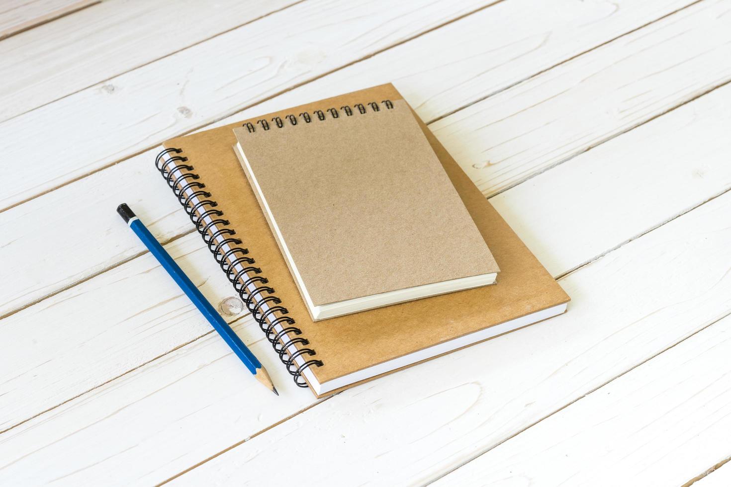 Notebook with blank pages and pencil on wood table photo