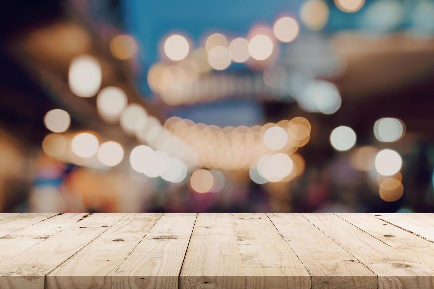 Empty wooden table and blurred background at night market festival people walking on road with copy space, display montage for product. photo