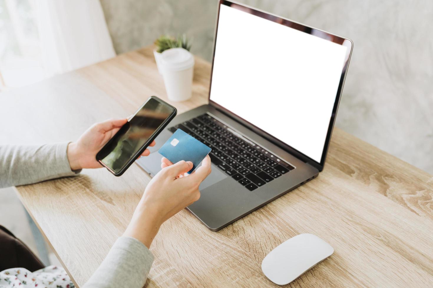 woman using smart phone and credit card for shopping online in coffee shop photo