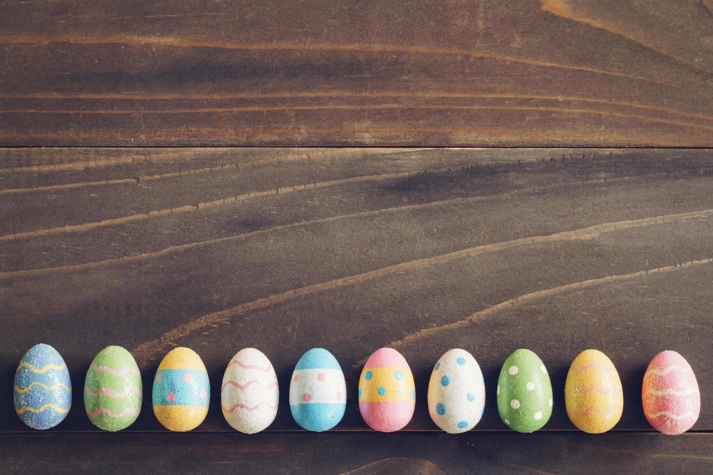 Top view of Easter eggs on rustic wood background with copy space photo