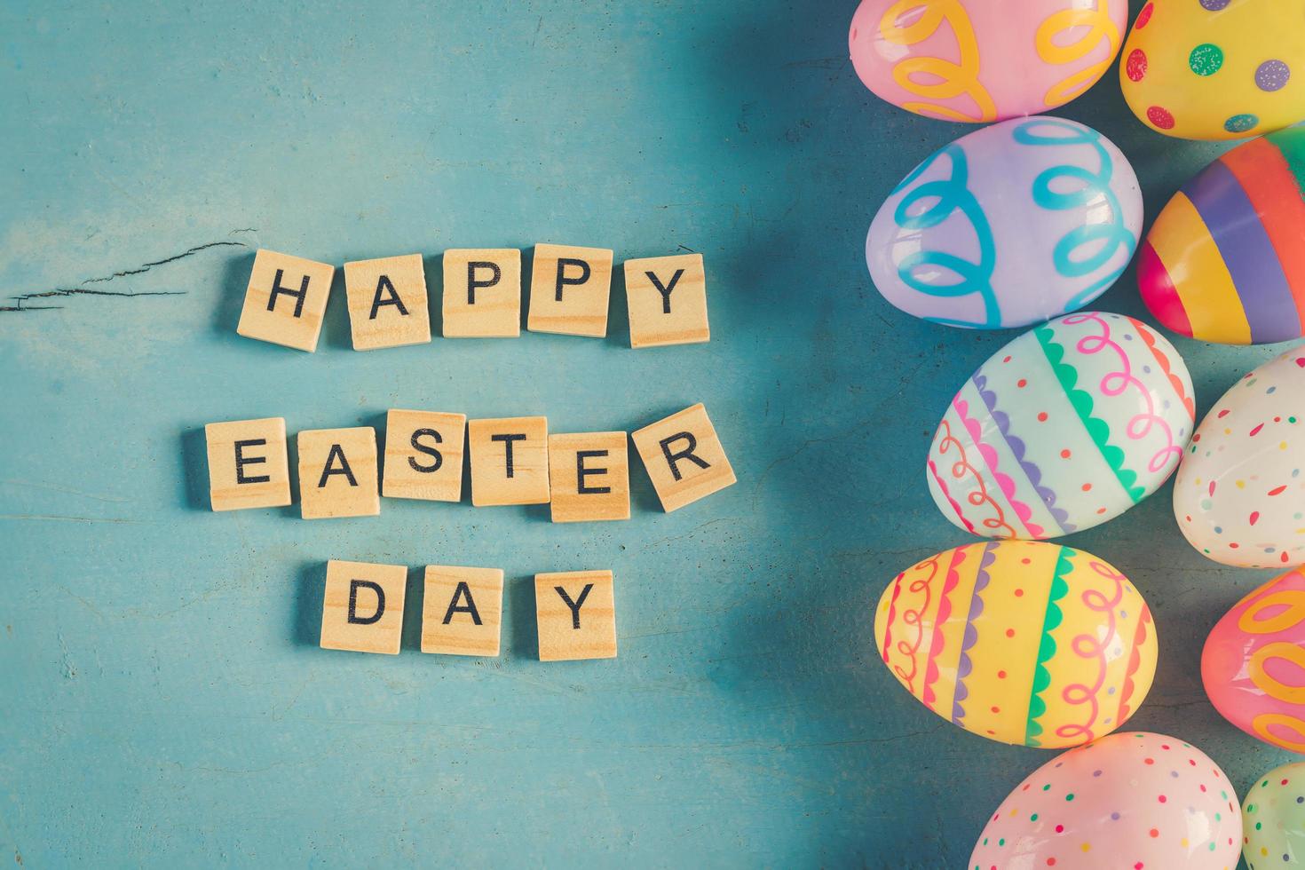 Colorful easter egg and wood text Happy Easter Day on blue pastel color wood background with space. photo