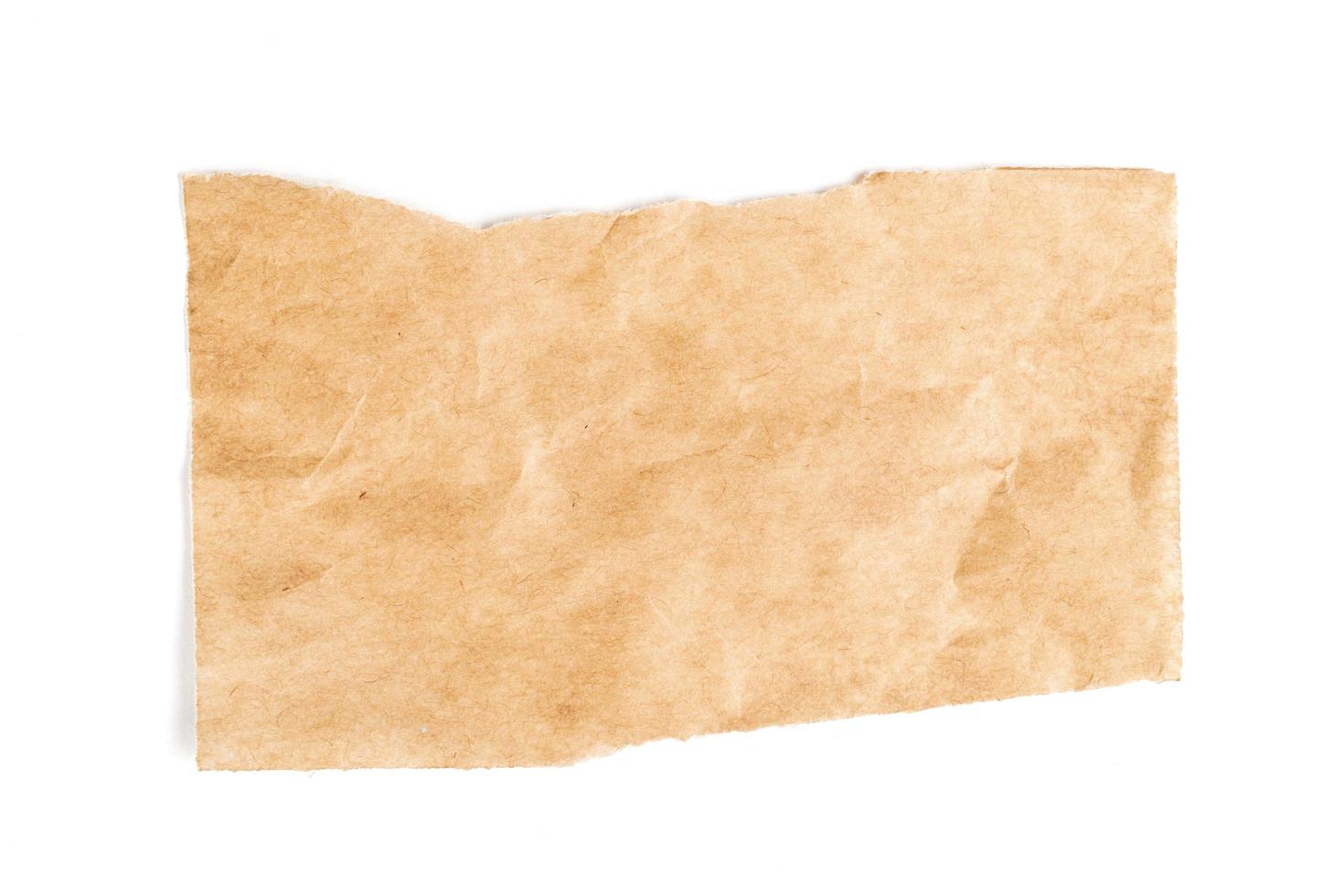 Close up of a ripped piece of brown paper on white background photo