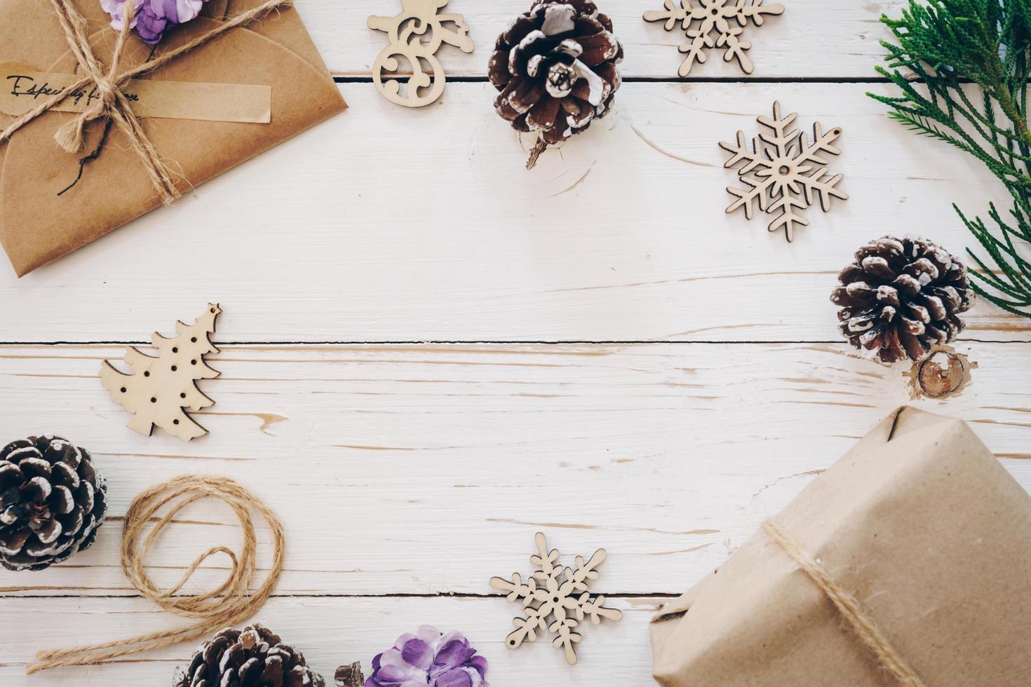 Top view of gift box and christmas card on wooden table with xmas decoration. photo