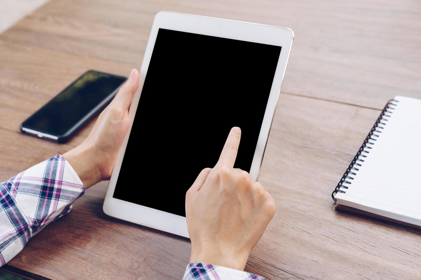 Hand woman using tablet computer on wooden table with Vintage toned. photo
