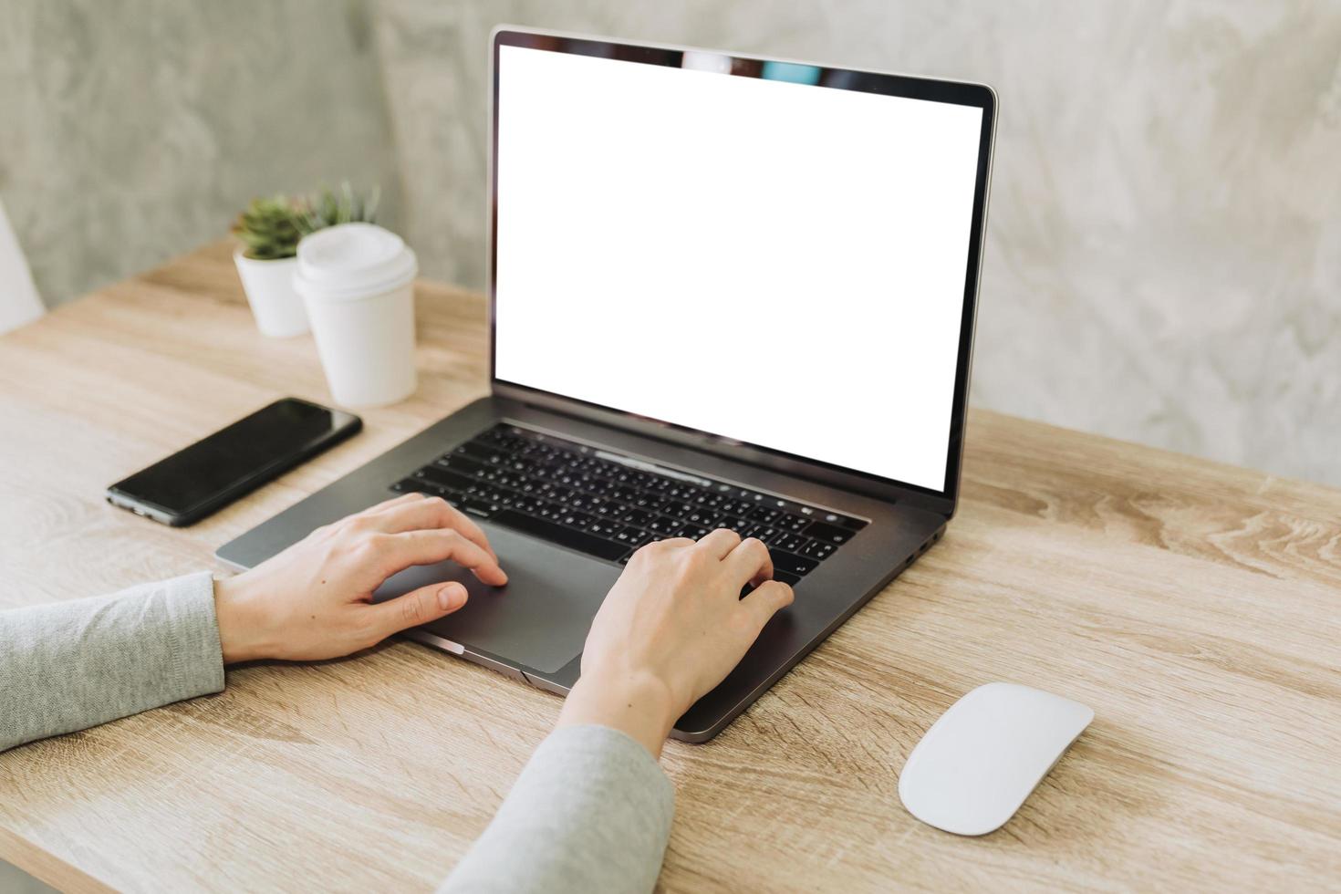 woman using laptop and working on wooden table photo