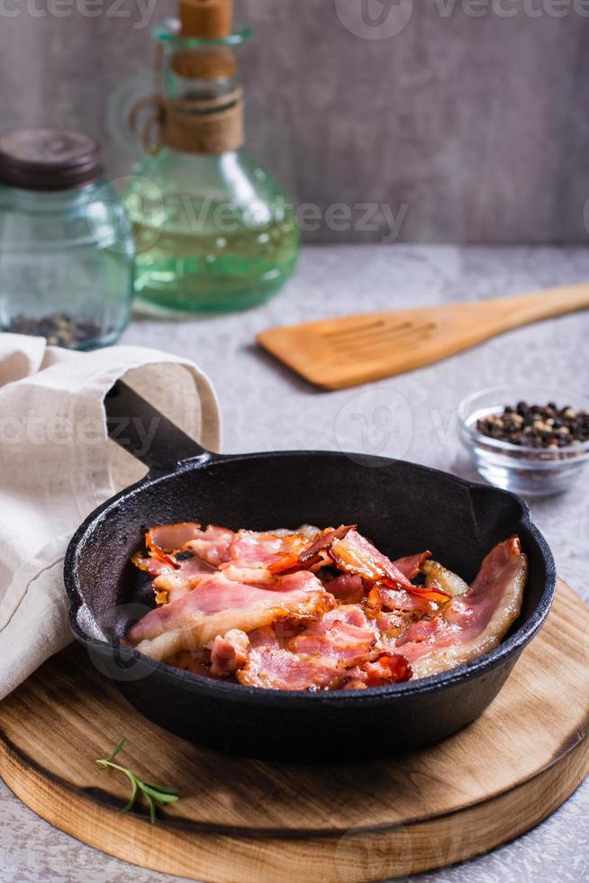 Fried bacon in a pan ready for dinner on the table. Vertical view photo