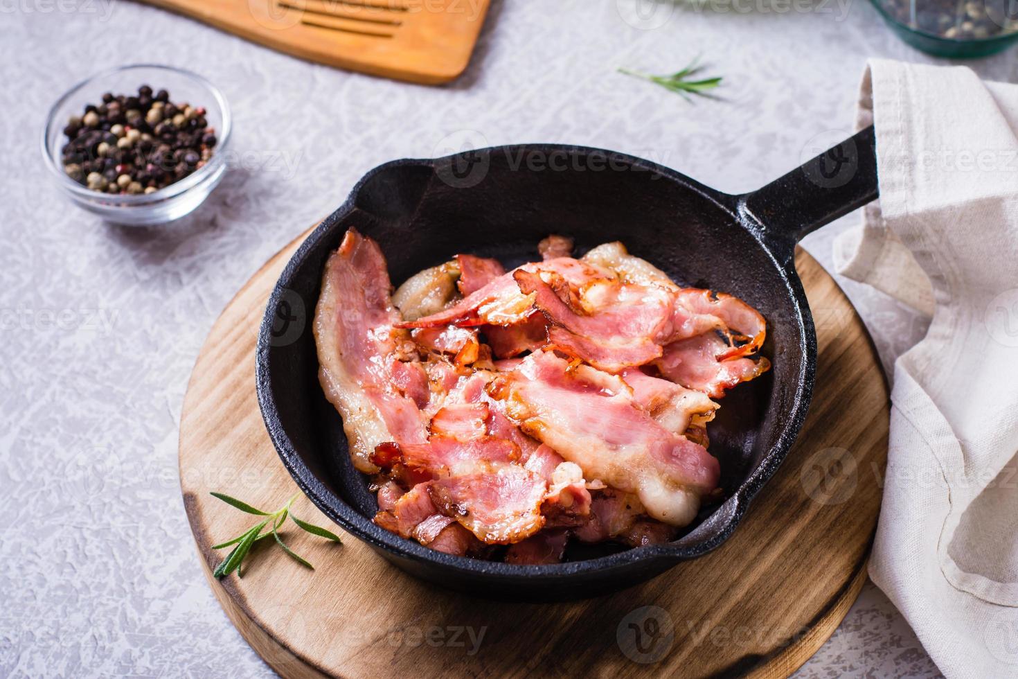 Crispy strips of bacon fried in a pan on the table. photo