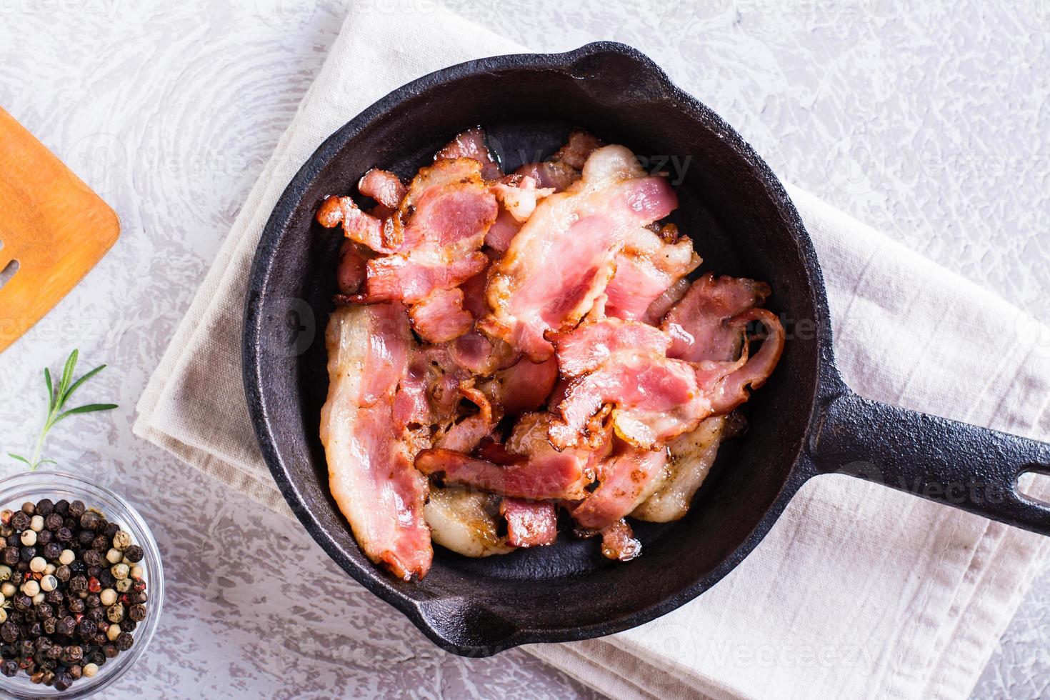 Fried bacon in a pan ready for dinner on the table. Top view. Closeup photo