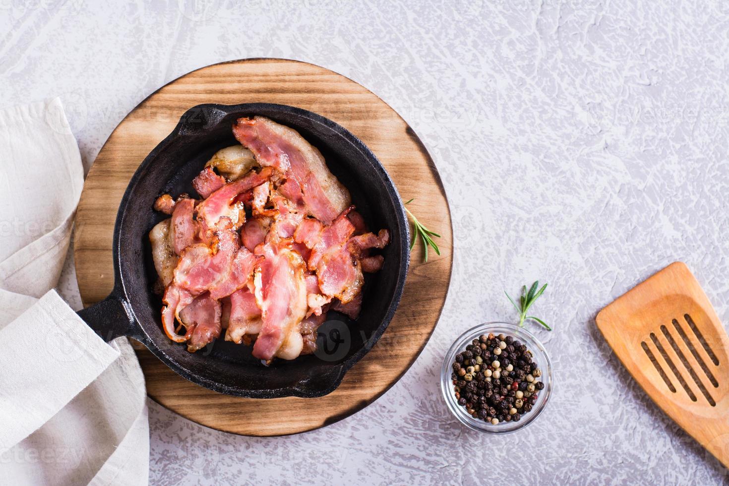 Fried bacon in a pan ready for dinner on the table. Top view photo