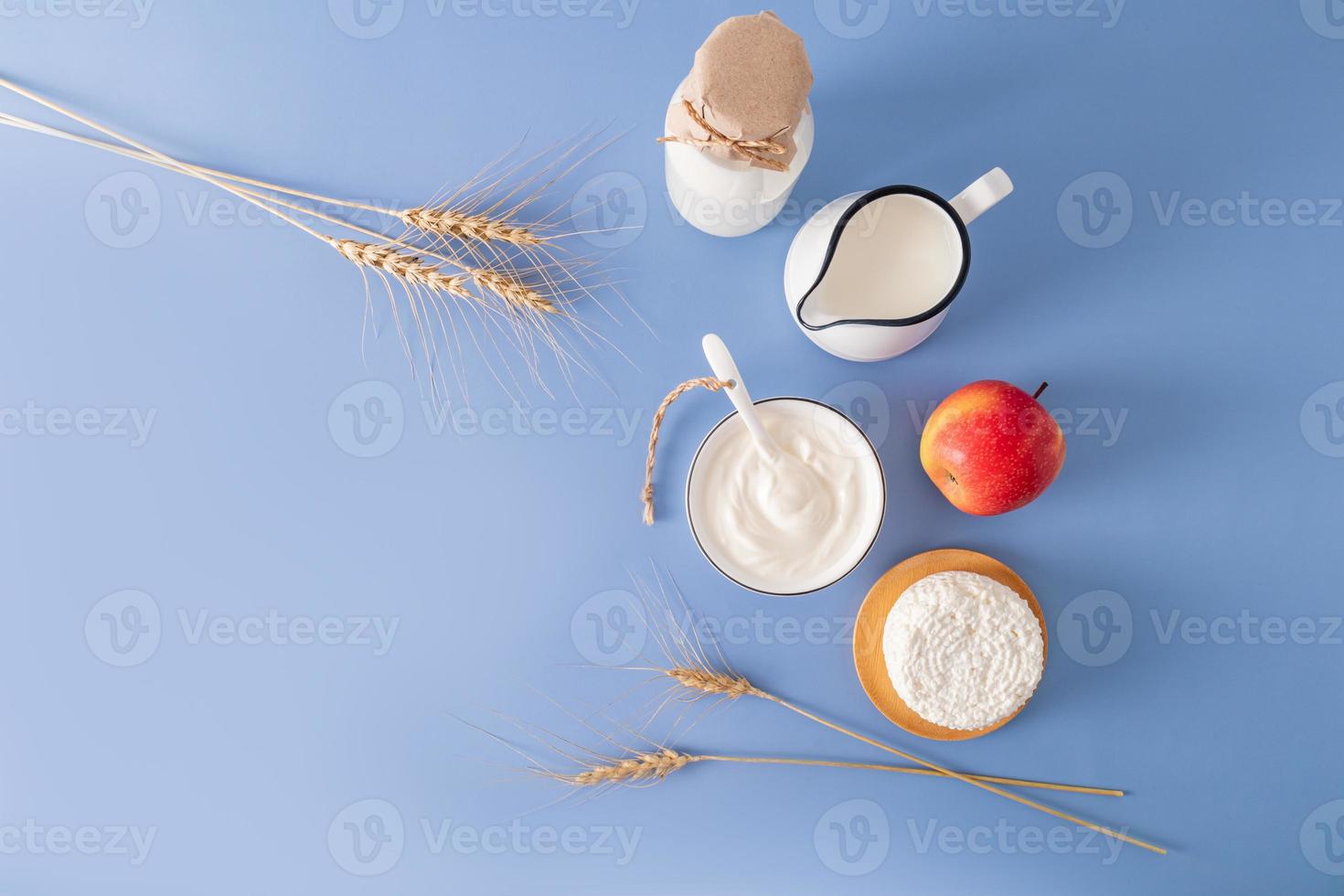 Beautiful festive background for the Jewish holiday of Shavuot with various traditional treats with a copy of the space. blue background. photo