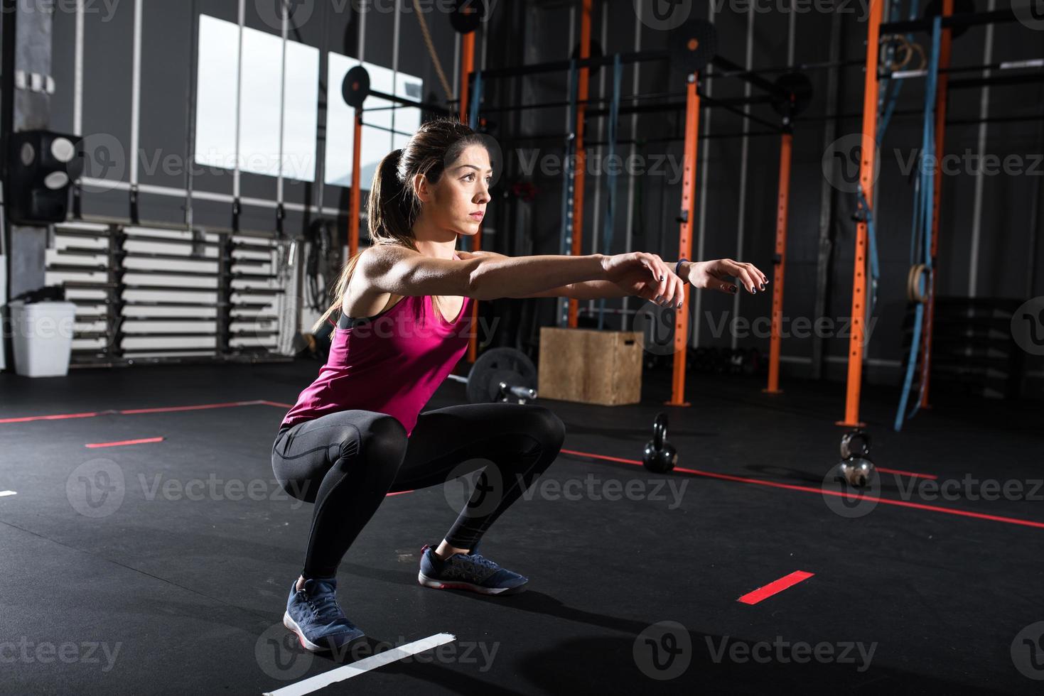 Athletic girl does squat exercises at the gym photo
