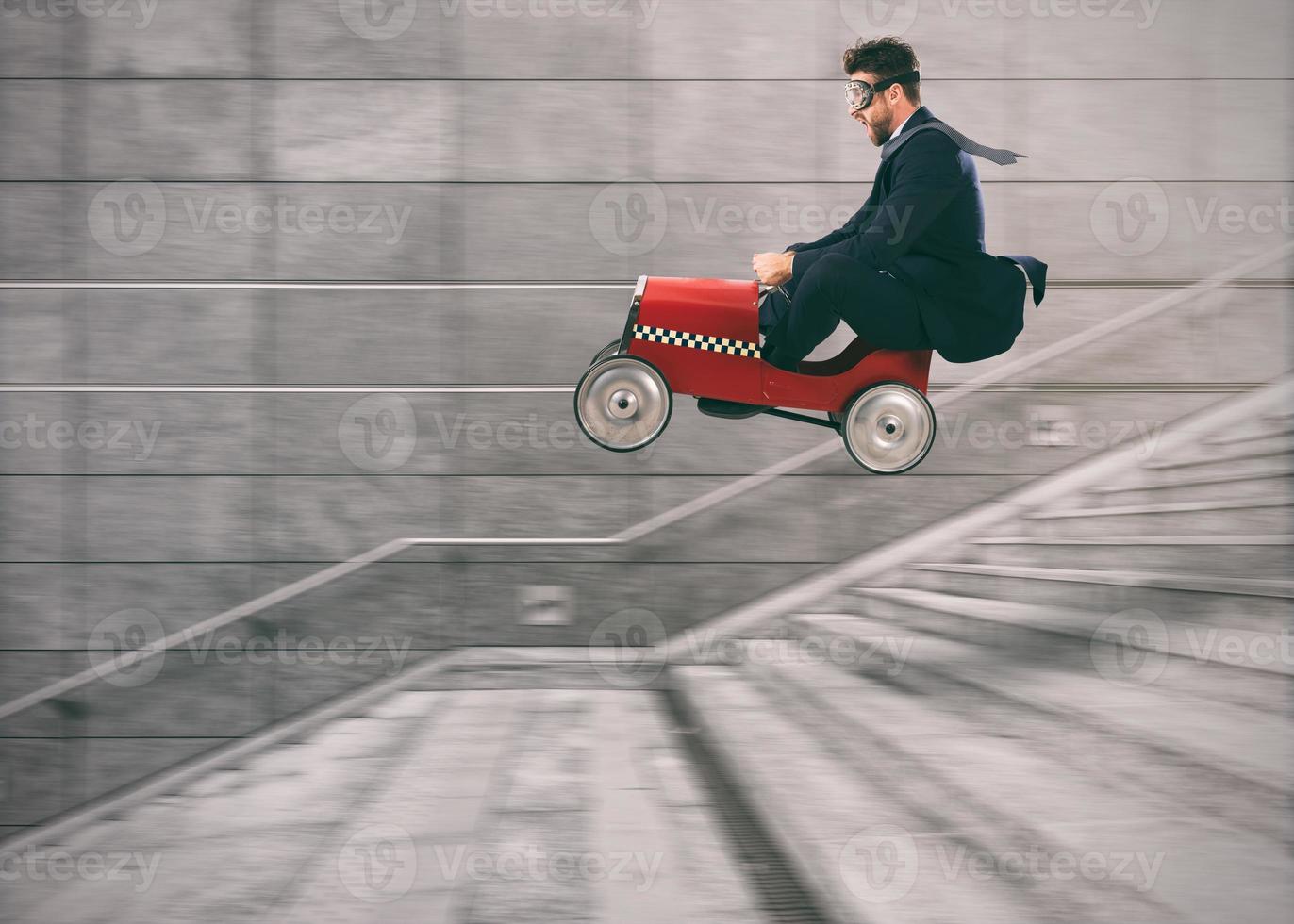 Reckless business man goes down the stairs with a car to get before the others. Concept of success and competition photo